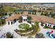 The clubhouse featuring a splash pad, decorative palm trees, a circular drive, and a central fountain at 9332 Sommerset Hills Dr, Davenport, FL 33896