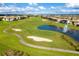 Scenic aerial view of a golf course with lush green fairways, sand traps, and a water fountain at 9332 Sommerset Hills Dr, Davenport, FL 33896