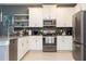 Modern kitchen featuring stainless steel appliances, white cabinets, and gray backsplash and countertops at 9332 Sommerset Hills Dr, Davenport, FL 33896