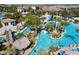 An aerial view of the expansive resort-style community pool including a lazy river with lush tropical landscaping at 9332 Sommerset Hills Dr, Davenport, FL 33896