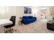 Comfortable sitting area featuring a plush blue couch, a modern table, and a view into a bedroom, ideal for relaxation at 9332 Sommerset Hills Dr, Davenport, FL 33896