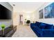 The cozy area features a comfortable blue sofa and a large-screen TV, perfect for relaxation and entertainment at 9332 Sommerset Hills Dr, Davenport, FL 33896