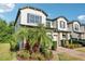 Charming townhome featuring lush landscaping, blue shutters, and a well-maintained exterior at 10404 Park Commons Dr, Orlando, FL 32832