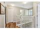 Bright hallway with wood floors, white railing and trim, and several doors at 10404 Park Commons Dr, Orlando, FL 32832