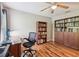 Office with wood floors, ceiling fan, desk and chair, and built-in bookshelves at 10404 Park Commons Dr, Orlando, FL 32832