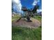 Neighborhood playground with slide and green space nestled amongst palm trees and townhomes at 10404 Park Commons Dr, Orlando, FL 32832