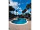 Sparkling community pool with brick surround and lounge chairs beneath blue skies and palm trees at 10404 Park Commons Dr, Orlando, FL 32832