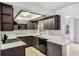 Well-lit kitchen with dark cabinets, stainless steel appliances, and breakfast bar at 1051 Arden St, Longwood, FL 32750