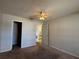 Bedroom with neutral walls, carpet, a ceiling fan and a view to the kitchen through an open door at 1081 S Hiawassee Rd # 726, Orlando, FL 32835