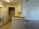 Kitchen area featuring white appliances and cabinets, a breakfast bar and view into the living area at 1081 S Hiawassee Rd # 726, Orlando, FL 32835