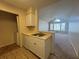 Kitchen with cream counters, stainless steel sink, wood-look flooring and view to the living room at 1081 S Hiawassee Rd # 726, Orlando, FL 32835