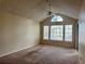 Carpeted living room with a ceiling fan, a large arched window, and natural light at 1081 S Hiawassee Rd # 726, Orlando, FL 32835