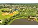 An aerial view shows the baseball field area, a lake with dock and the surrounding community at 1121 Arbor Glen Cir, Winter Springs, FL 32708