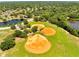 Aerial view of three baseball fields in a community park surrounded by trees and a pond at 1121 Arbor Glen Cir, Winter Springs, FL 32708