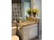 Cozy bathroom features a glass vessel sink, granite counters, and bright yellow flowers at 1121 Arbor Glen Cir, Winter Springs, FL 32708