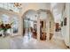 Elegant foyer with tile flooring, decorative columns, and stained glass doors leading to the formal dining room at 1121 Arbor Glen Cir, Winter Springs, FL 32708