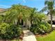 Inviting front entrance surrounded by lush tropical landscaping and a stone walkway leading to a glass front door at 1121 Arbor Glen Cir, Winter Springs, FL 32708