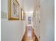 Hallway featuring hardwood floors and decorative paintings leading to other rooms at 1121 Arbor Glen Cir, Winter Springs, FL 32708