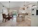 Bright eat-in kitchen featuring an island, granite countertops, tile floors, and views of a backyard pool area at 1121 Arbor Glen Cir, Winter Springs, FL 32708