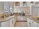 Well-lit kitchen with granite countertops, white cabinets, tile floors, and modern appliances at 1121 Arbor Glen Cir, Winter Springs, FL 32708