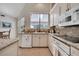 The kitchen showcases white cabinets, granite countertops, stainless steel appliances and a window view of the pool at 1121 Arbor Glen Cir, Winter Springs, FL 32708