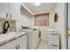 Laundry room with modern washer, dryer, sink, and ample storage space at 1121 Arbor Glen Cir, Winter Springs, FL 32708