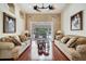 Cozy living room featuring hardwood floors, comfortable sofas, and sliding glass doors to the outdoor pool area at 1121 Arbor Glen Cir, Winter Springs, FL 32708