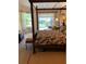 Main bedroom with a four-poster bed and access to the lanai and pool area at 1121 Arbor Glen Cir, Winter Springs, FL 32708