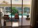 Covered patio looking out to a screened in pool with lounge chairs and landscaping at 1121 Arbor Glen Cir, Winter Springs, FL 32708