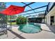 Enclosed pool area featuring a charming patio table beneath a red umbrella with a clear view of the pool at 1121 Arbor Glen Cir, Winter Springs, FL 32708