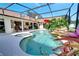 Beautiful screened-in pool area with a rock waterfall feature and spa, surrounded by lush landscaping at 1121 Arbor Glen Cir, Winter Springs, FL 32708