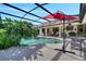 Inviting pool area with a screened enclosure, featuring a waterfall, spa, and outdoor dining under a red umbrella at 1121 Arbor Glen Cir, Winter Springs, FL 32708