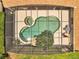 Aerial shot of a screened in pool with mature landscaping, unique design, and outdoor furniture at 1121 Arbor Glen Cir, Winter Springs, FL 32708