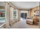 Relaxing sitting area with a lounge chair, access to the pool area, and natural light from large windows at 1121 Arbor Glen Cir, Winter Springs, FL 32708