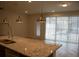 Open concept kitchen with a stone kitchen island that overlooks the living room and pool access at 1264 Blue Island Dr, Clermont, FL 34714