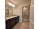 Bathroom featuring granite countertop with dual sinks and glass enclosed shower at 1286 Shoreside St, Clermont, FL 34714