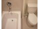 Clean bathroom featuring a white bathtub and toilet, set against a tiled backdrop at 1286 Shoreside St, Clermont, FL 34714