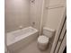 Bright, clean bathroom with a shower-tub combo, toilet, and neutral tile at 1286 Shoreside St, Clermont, FL 34714