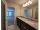 Bathroom featuring granite countertop with dual sinks and view to bedroom at 1286 Shoreside St, Clermont, FL 34714