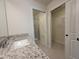 Bright bathroom featuring a granite vanity top, walk-in shower, and spacious closet at 1286 Shoreside St, Clermont, FL 34714