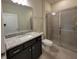 Bathroom featuring a granite countertop, dark cabinets, and a tiled walk-in shower at 1286 Shoreside St, Clermont, FL 34714