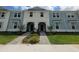 Attractive townhome showing a light blue exterior, covered entries, and colorful landscaping at 1286 Shoreside St, Clermont, FL 34714