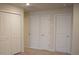 Hallway featuring multiple white doors and a closet with bi-fold doors at 1286 Shoreside St, Clermont, FL 34714