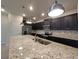 Kitchen features stainless appliances, dark cabinets and a large island with granite counters and sink at 1286 Shoreside St, Clermont, FL 34714