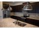 Modern kitchen featuring stainless steel appliances, dark cabinets, and granite countertops at 1286 Shoreside St, Clermont, FL 34714