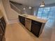 Kitchen island with sink, granite counters, dark cabinets and view of the pool through the windows at 1286 Shoreside St, Clermont, FL 34714