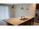 Kitchen island with granite countertops, stainless steel sink, and modern pendant lighting at 1286 Shoreside St, Clermont, FL 34714