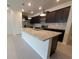Modern kitchen with granite countertops, stainless steel appliances, dark cabinetry, and a central island at 1286 Shoreside St, Clermont, FL 34714
