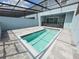 Backyard featuring a pool, screened enclosure, and paved patio for outdoor enjoyment at 1286 Shoreside St, Clermont, FL 34714