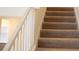 Carpeted staircase with white banister and natural light at 1286 Shoreside St, Clermont, FL 34714